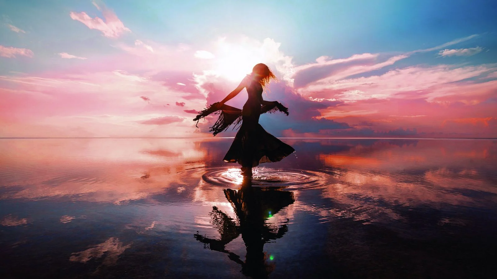 El universo de Alaya Beach: una silueta que baila en el agua, a contraluz del atardecer.